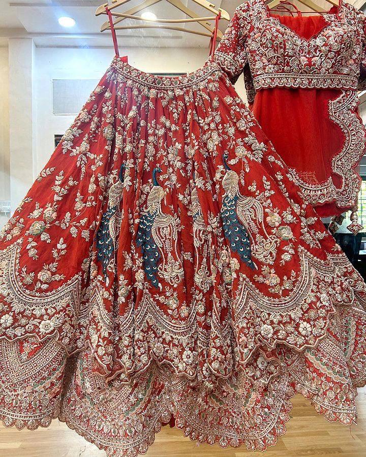 Red lehenga twirl shot showing 4 meter flare with can-can layers