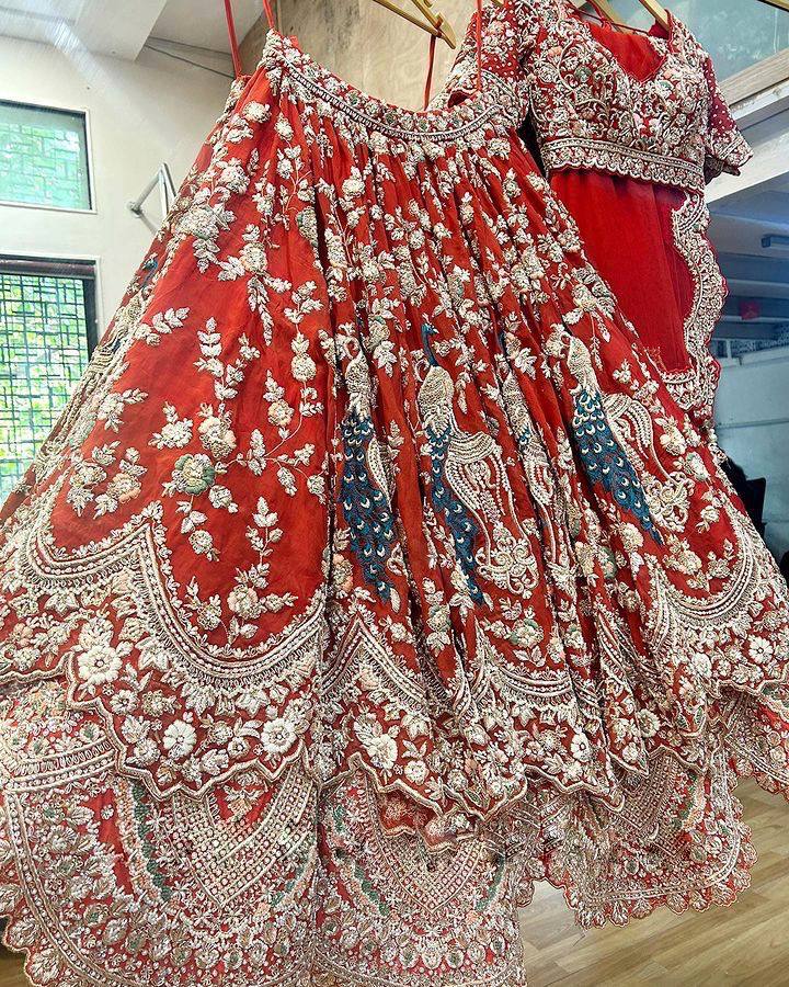 Close up of peacock embroidery on red Faux Georgette lehenga
